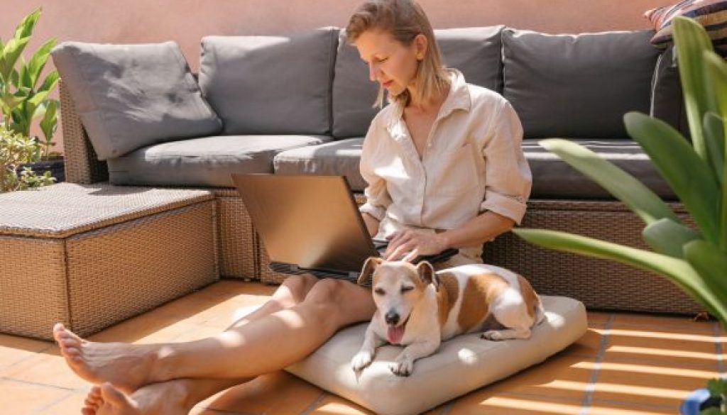 Woman sitting on outdoor couch with dog